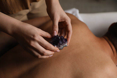 Man undergoing crystal therapy to heal or restore his aura indoors, closeupの写真素材