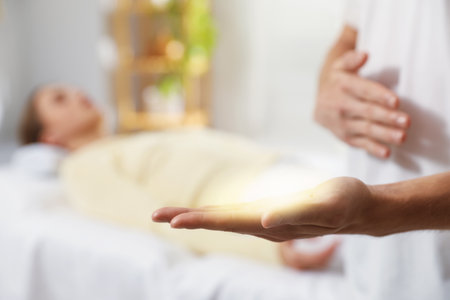 Reiki master showing aura in his hand during therapy indoors, closeupの写真素材