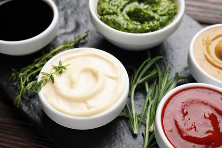 Different sauces and herbs on wooden table, closeupの写真素材
