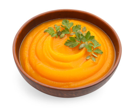 Tasty pumpkin cream soup with parsley and seeds in bowl isolated on whiteの写真素材