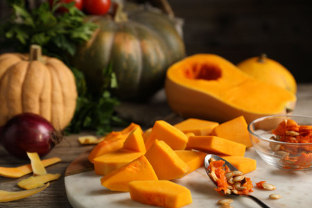 Fresh pumpkins, seeds, peels and ingredients on wooden table, closeupの写真素材