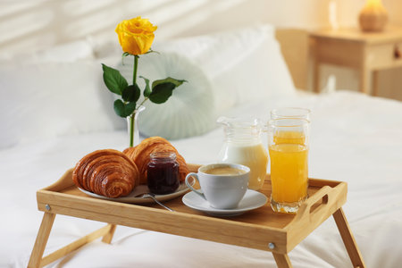 Tray with delicious breakfast on bed in hotel room, closeupの写真素材