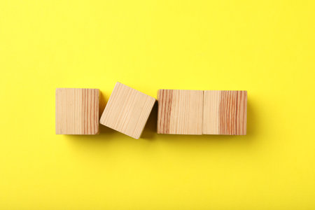Wooden cubes on yellow background, top viewの写真素材