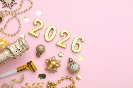 New 2026 Year. Golden numbers, shiny baubles, beads, confetti and bottle of sparkling wine on pink...