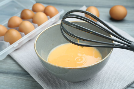 Beaten eggs in bowl on table, closeupの写真素材