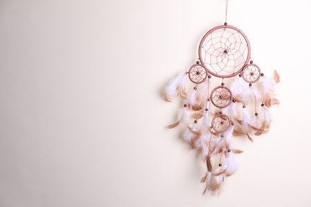Beautiful dream catcher hanging against light gray background, space for textの写真素材