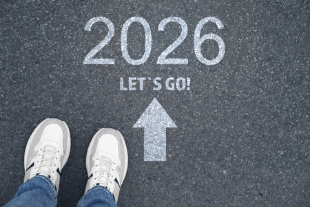 New Year. Man standing near arrow, phrase Let's Go and numbers 2026 on asphalt, top viewの写真素材