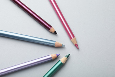 Colorful eye pencils on light background, flat lay. Space for textの写真素材