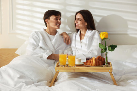 Happy couple enjoying delicious breakfast in bed, selective focus. Hotel room serviceの写真素材