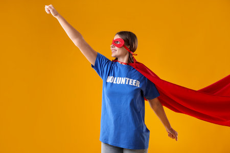 Volunteer wearing superhero costume on yellow backgroundの写真素材
