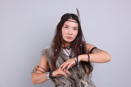 Shaman woman in feather headdress on light gray background