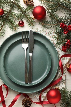 Festive table setting with Christmas decor on light wooden background, flat layの写真素材