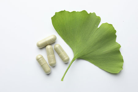 Ginkgo biloba leaf and pills on white background, flat layの写真素材