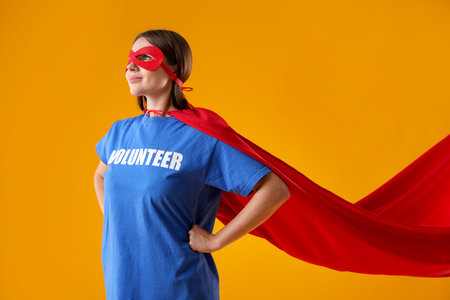 Volunteer wearing superhero costume on yellow backgroundの写真素材