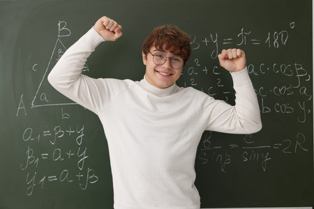 Back to school. Happy student near chalkboard with math assignment indoors
