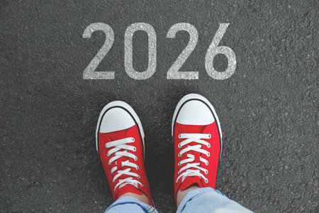New Year. Man standing in front of numbers 2026 on asphalt, top viewの写真素材