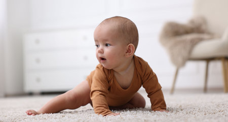 Portrait of cute little baby on floor at home