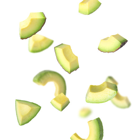 Fresh avocado slices falling on white background