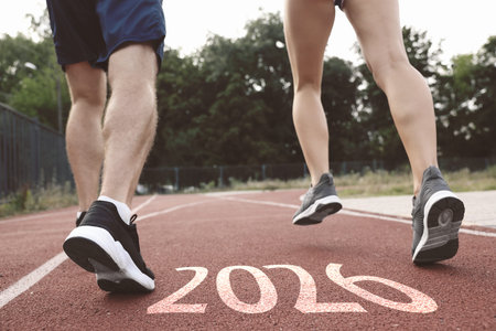 New 2026 Year. Sporty couple running on road with numbers, closeup