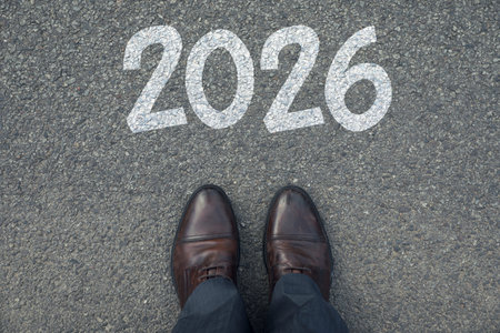 New Year. Man standing in front of numbers 2026 on asphalt, top view