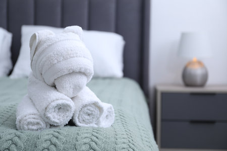 Cute elephant made with towel on bed indoors, closeup. Space for textの写真素材