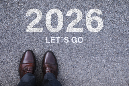 Man standing in front of the phrase Let's Go and numbers 2026 on asphalt, top viewの写真素材