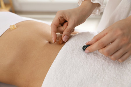 Woman undergoing crystal therapy to heal or restore her aura indoors, closeupの写真素材