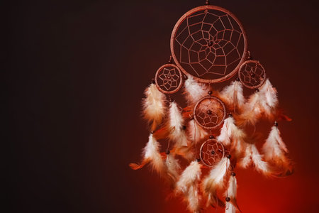 Beautiful dream catcher in color light on dark background. Space for text