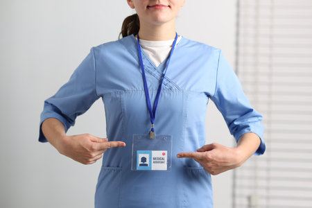 Medical assistant pointing at her badge in clinic, closeupの写真素材