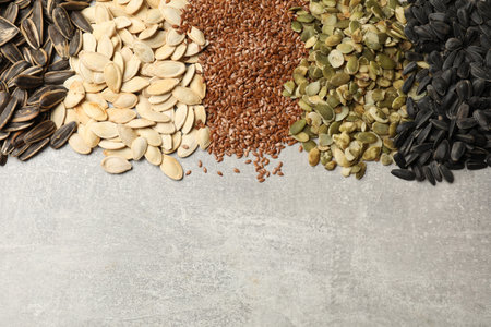 Different seeds on gray table, flat lay. Space for textの写真素材