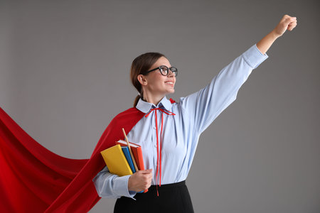 Teacher wearing superhero cape on gray backgroundの写真素材