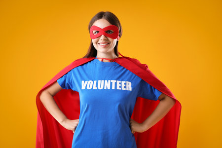Volunteer wearing superhero costume on yellow backgroundの写真素材