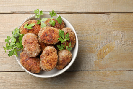 Tasty meat patties with parsley o wooden table, top view. Space for textの写真素材