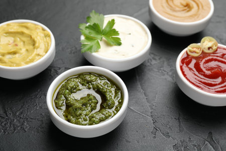 Different sauces and parsley on black table, closeupの写真素材