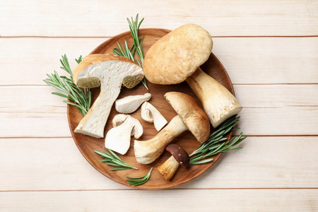 Fresh mushrooms and rosemary on wooden table, top viewの写真素材