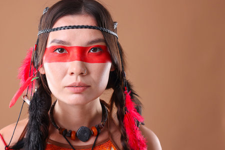 Shaman woman with face painting on pale brown background, space for text