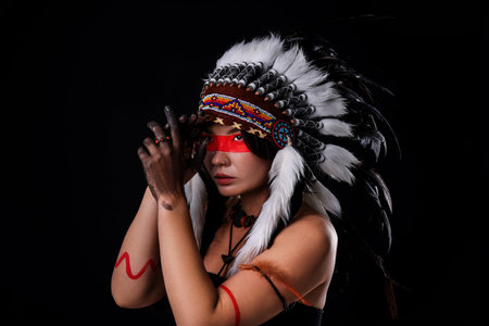 Shaman woman in native American Indian headdress with face painting on black background