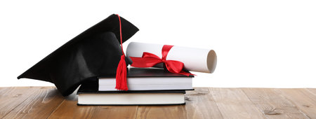 Graduation cap, diploma and books on wooden table against white backgroundの写真素材