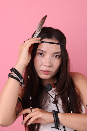Shaman woman in feather headdress on pink background
