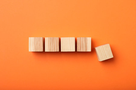 Wooden cubes on orange background, top viewの写真素材