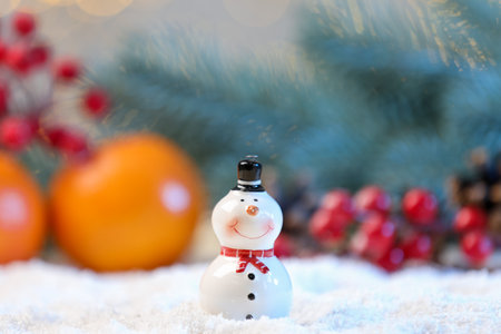 Cute decorative snowman on artificial snow against blurred background, closeupの写真素材
