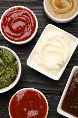 Different sauces in bowls on wooden table, flat layの写真素材