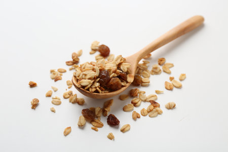 Tasty granola with nuts and raisins on white table, closeupの写真素材