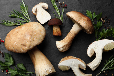Fresh porcini mushrooms and spices on black table, flat layの写真素材