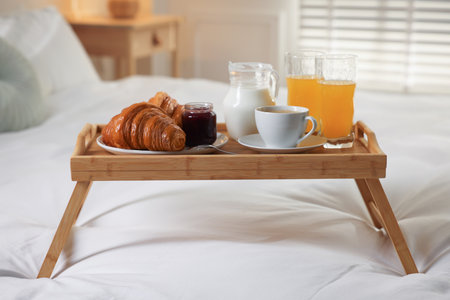 Tray with delicious breakfast on bed in hotel room, closeupの写真素材