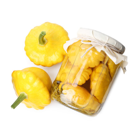 Pickled pattypan squashes in glass jar and fresh vegetables isolated on white, top viewの写真素材