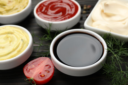 Different sauces and herbs on wooden table, closeupの写真素材
