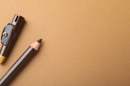 Pencil and sharpener on brown background, top view. Space for textの写真素材
