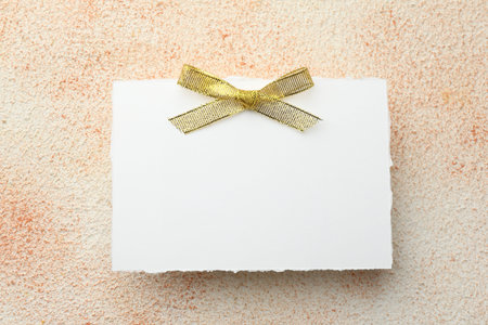 Blank card on textured beige background, top view. Mockup for designの写真素材