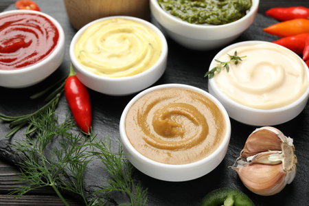 Different sauces and herbs on wooden table, closeupの写真素材